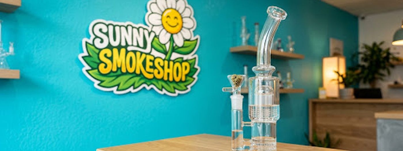Mostrador de Sunny Smokeshop con pieza de vidrio y el logo en la pared
